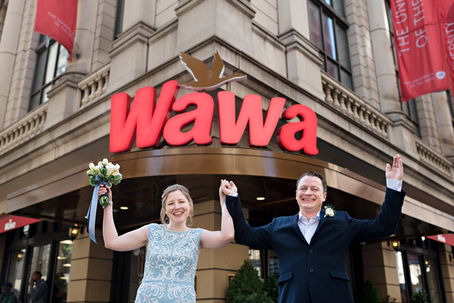 A wedding couple jumping for joy in front of Wawa in Philly.